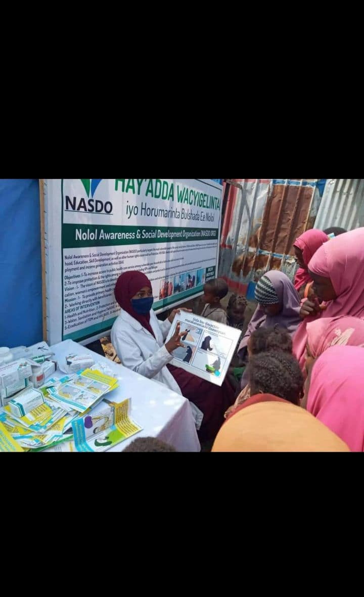 Health professionals showing families how to use treated mosquito nets in Baarey